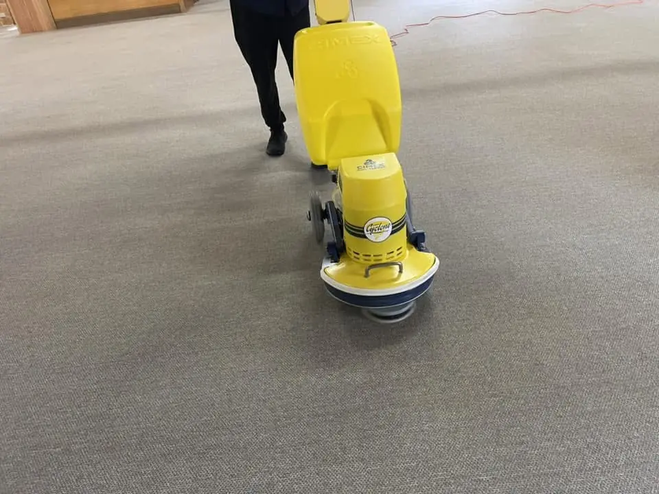 Steamy Wonder Cleaning operating a rotary carpet cleaning machine on commercial carpet