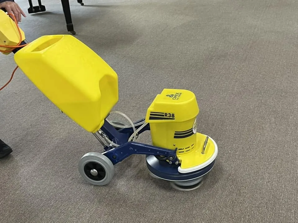 rotary carpet cleaning machine being used on a beige commercial carpet